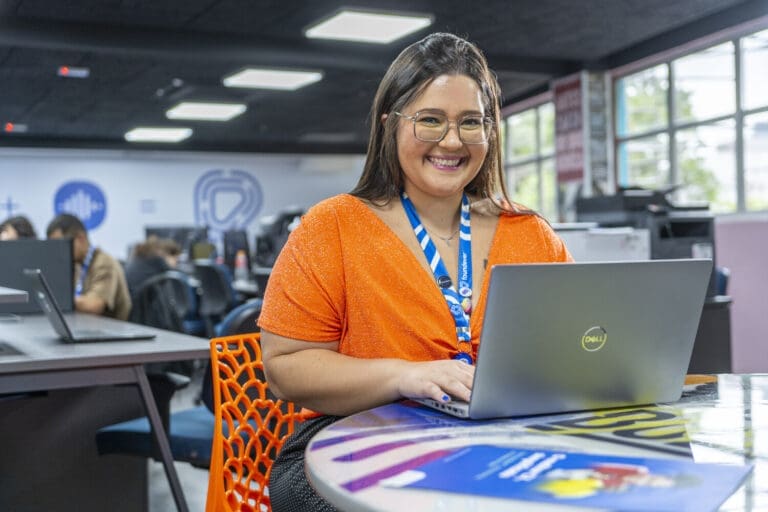 Foundever employee smiling whilst using laptop