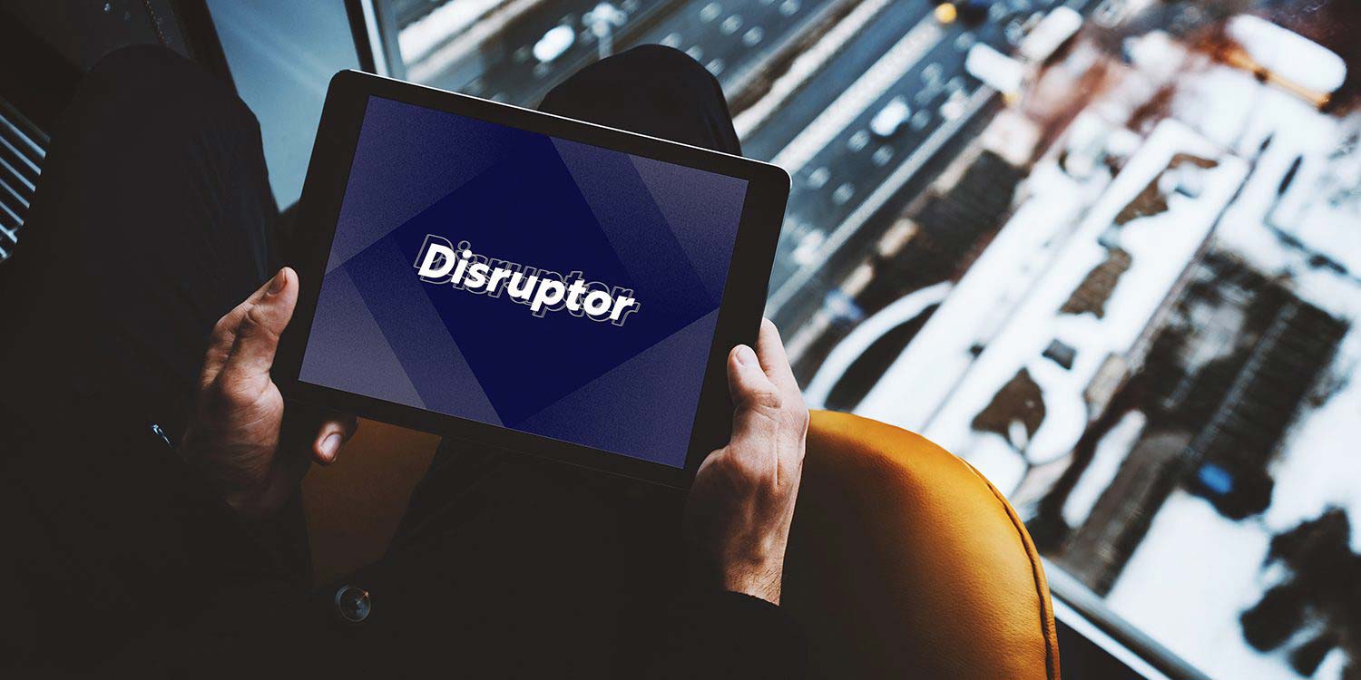 A person holding a tablet with the word "Disruptor" displayed on it.