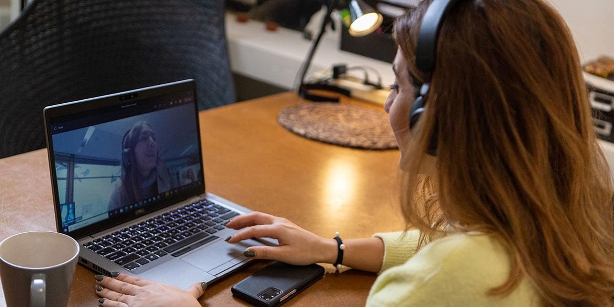 Woman with headphones in an online meeting. The future of work