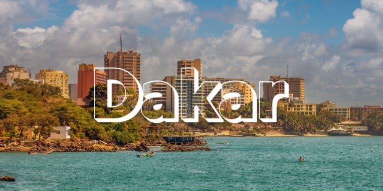 The word "Dakar" is in large over photo of a coastal view