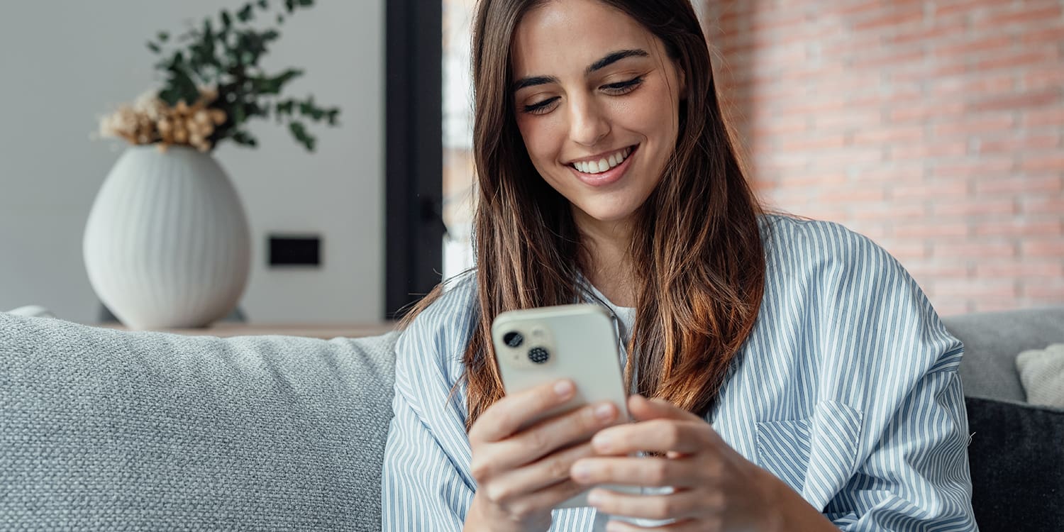 A young woman looks at her smartphone