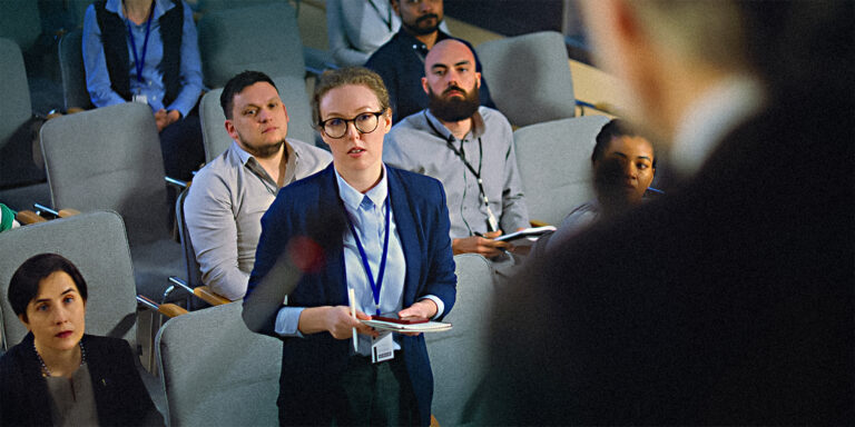 A group of reporters are attending a government meeting