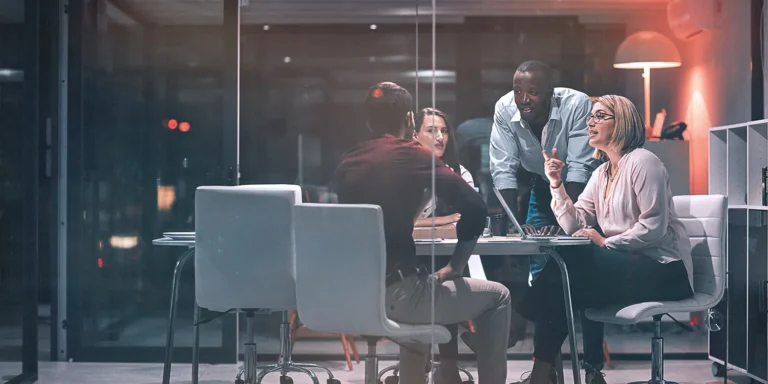 A group of 4 people having a discussion in a conference room
