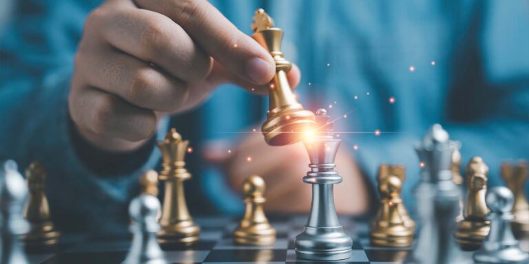 Closeup of a hand moving a game piece on a chess board