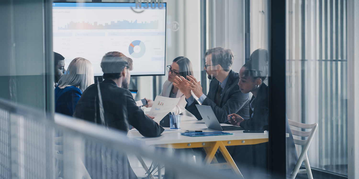 People meet in an office conference room and look like they are planning