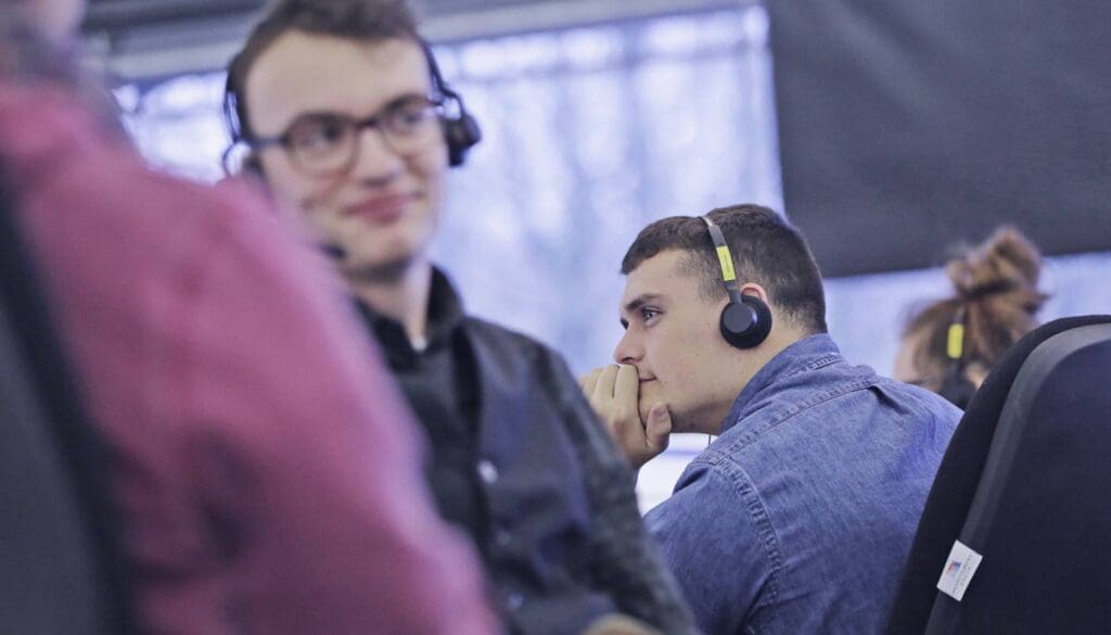 A team of customer sales and retention agents wearing headphones.